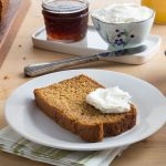Sweet Potato Bread with a Pad of Butter on Top on a White Plate