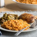 View of Mashed Sweet Potatoes on a Plate with Meat and Vegetables on a White Plate